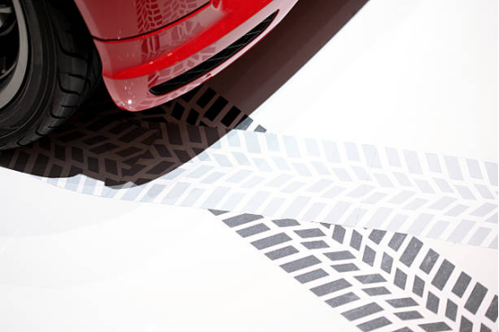 Applying protective sealant on garage floor to prevent tire marks.