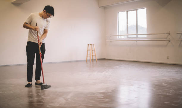 Man cleaning concrete floor for garage floor coating.