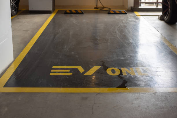 Dark EV-only parking spot with a durable garage floor coating, showing yellow lines.