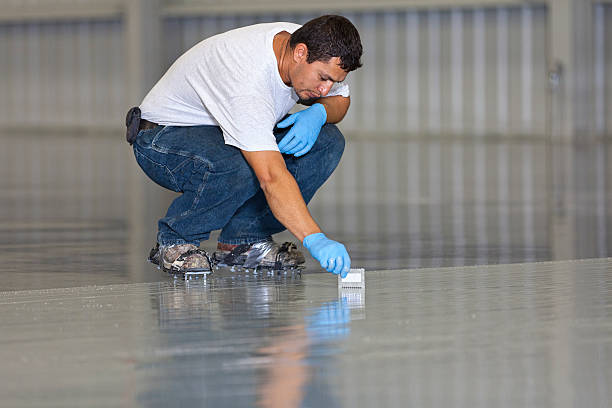 Man inspecting new garage floor coating application.