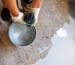 Worker mixing materials for durable garage floor coating application.