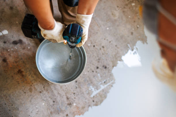 Worker mixing materials for durable garage floor coating application.