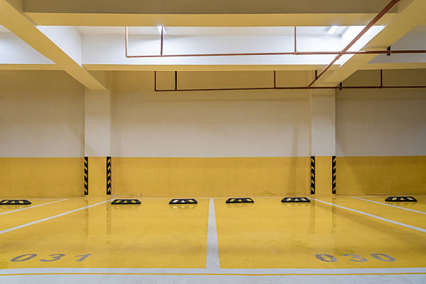Bright yellow garage floor coating in a clean, empty underground parking garage.