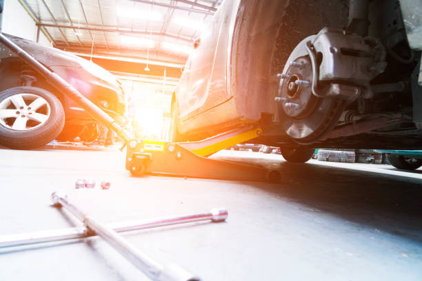 Car lifted for brake repair on a bright, durable garage floor coating.