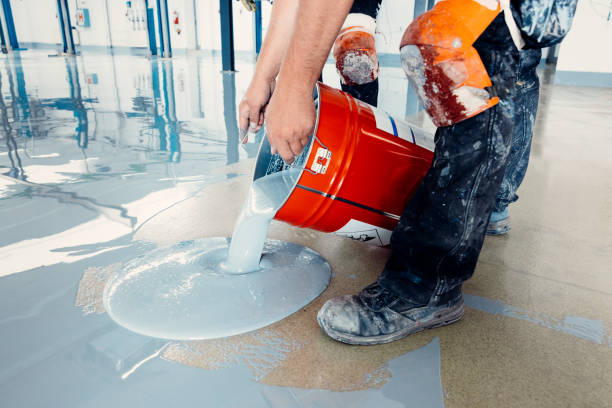 Pouring self-leveling resin for a smooth, protective garage floor coating.